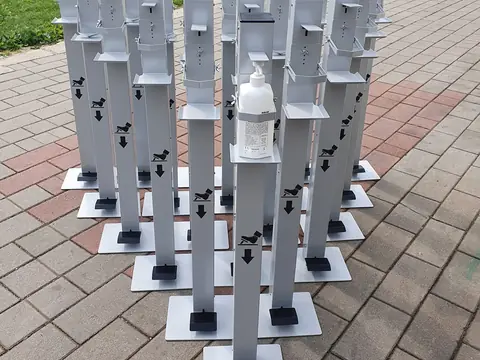 Kovinska stojala za razkužilo, postavljena v vrste